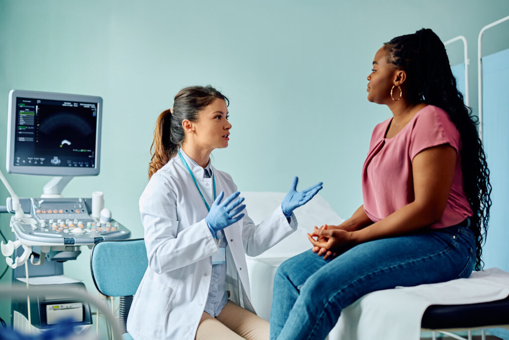 Female doctor explaining something to female patient in a medical facility.